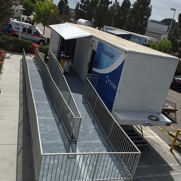 A truck parked on top of a sidewalk near a street.