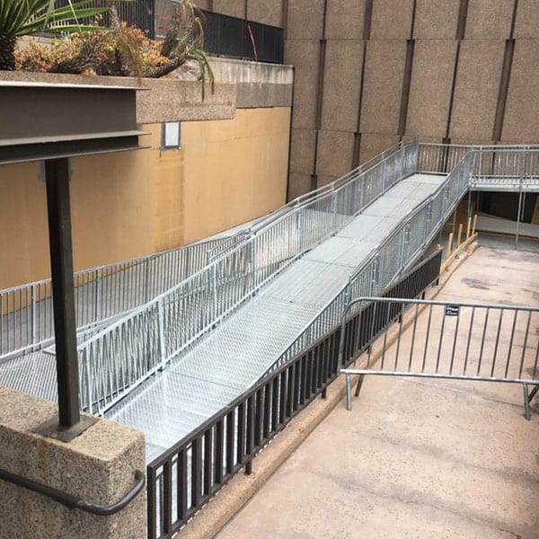 A walkway with metal railing and concrete steps.