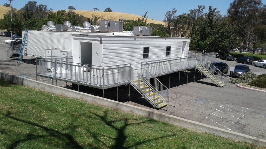 A white trailer with stairs leading to the top.