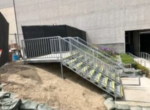 A metal staircase with yellow steps going up it.