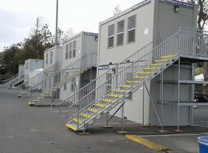 A row of white buildings with stairs going up them.